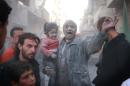A Syrian man holds a crying girl following an air strike by government forces on the Sahour neighbourhood of Aleppo on March 6, 2014