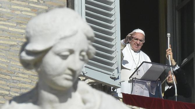 Pope Francis greets the crowd from the window of the Apostolic Palace overlooking St.Peter's Square during his Angelus prayer at the Vatican, on January 1, 2015