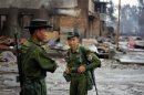 Soldiers patrol through a neighbourhood that was burnt during recent violence in Sittwe