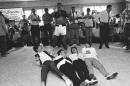 FILE - In this Feb. 18, 1964, file photo, boxer Muhammad Ali, or Cassius Clay at the time, beats his chest in triumph after toppling Britain's Beatles at his training camp in Miam i Beach, Fla. The Beatles, left to right: Paul McCartney; John Lennon; George Harrison and Ringo Starr, were on Holiday in the resort after their American tour. Ali, the magnificent heavyweight champion whose fast fists and irrepressible personality transcended sports and captivated the world, has died according to a statement released by his family Friday, June 3, 2016. He was 74. (AP Photo/File)