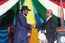 South Sudan's President Salva Kiir (L) shakes hands with Uganda's President Yoweri Museveni (R) after signing a peace agreement to end 20 months of war in the world's youngest nation, August 26, 2015 in Juba