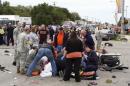 People attend to the injured at the scene of a car crash after a car drove into a homecoming parade at Oklahoma State University in Stillwater