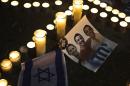 Candles placed next to a picture of three Israeli teenagers who were abducted and killed, in Tel Aviv's Rabin Square