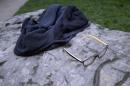 A child's glasses and a jacket lie on a rock in the Park Monceau, after a lightning strike in Paris, Saturday, May 28, 2016. A Paris fire service spokesman says 11 people including eight children have been hit by lightning in a Paris park after a sudden spring storm overtook a child's birthday party. The victims had sought shelter Saturday under a tree at Park Monceau, a popular weekend hangout for well-to-do families in Paris. (AP Photo/Mstyslav Chernov)