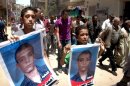 Egyptian boys hold posters of Ahmed Hussein Eid who was fatally stabbed by three bearded men during his funeral procession in the city of Suez, Egypt, Wednesday, July 4, 2012. The murder of a university student by suspected militants as his girlfriend looked on is fueling fears in Egypt that vigilante groups seeking to enforce a strict interpretation of Islam's teachings may be feeling confident with an Islamist president in office to take over the streets. (AP Photo)