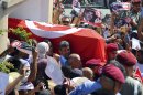 Tunisians carry the coffin of Tunisian opposition politician Mohammed Brahmi out of his home in El Ghazela, in the suburb of Tunis, prior to the funerals in Tunis, Saturday July, 27, 2013. Mohamed Brahmi was shot 14 times in front of his home within sight of his family on Thursday, plunging the country into a political crisis and unleashing demonstrations around the country blaming the government for the assassination. (AP Photo/Hassene Dridi)