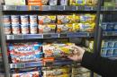 A man takes a yogurt pack from a refrigerator in a supermarket in Paris, Thursday, March 12, 2015. France's competition authority handed the country's top yogurt makers euro192 million ($203 million) in fines Thursday for fixing prices over the course of several years, striking secret deals in hotel rooms and on special phone lines created to avoid detection. (AP Photo/Michel Euler)