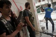 Free Syrian Army fighters exchange fire with regime forces in the Salaheddin neighbourhood of Syria's northern city of Aleppo. Syrian forces backed by helicopter gunships and tanks launched a deadly assault on parts of Damascus on Wednesday, activists said, as the regime battles to stamp out rebel resistance in the capital