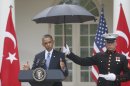 A Marine holds a umbrella as President Barack Obama speaks during his joint news conference with Turkish Prime Minister Recep Tayyip Erdogan, Thursday, May 16, 2013, in the Rose Garden of the White House in Washington. (AP Photo/Charles Dharapak)
