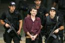 FILE - This March 19, 2007 file photo, shows Italian leftist fugitive activist Cesare Battisti, center, as he is escorted by Federal Police officers upon his arrival at Brasilia's airport. Brazil's federal police announced Thursday, March 12, 2015, tha they have arrested the former Italian militant Cesare Battisti on a judge's order. The arrest on Thursday of Battisti, who is now being held in Sao Paulo, comes despite his being granted asylum in 2010 by former President Luiz Inacio Lula da Silva and having the Supreme Court approve that asylum in 2013. Battisti had been convicted in Italy for four murders (AP Photo/Eraldo Peres, File)
