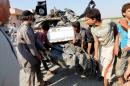 People carry a remnant of a war plane that crashed on the outskirts of Raqqa in northeast Syria