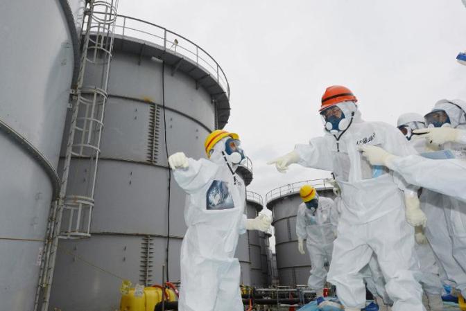 Fukushima governador Yuhei Sato (3 R) inspeciona tanques de água contaminada na usina nuclear de Fukushima em 15 de outubro de 2013