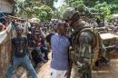 A man speaks to a French soldier during a disarmament operation in the Combattant neighbourhood near the airport of Bangui, on December 9, 2013