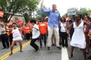 Bill de Blasio, running in the NYC Mayor's race, foreground second from right, dances with his family as he makes his way along Eastern Parkway in the Brooklyn borough of New York during the West Indian Day Parade, Monday, Sept. 2, 2013. (AP Photo/Tina Fineberg)