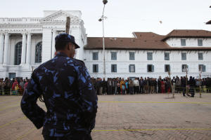 A Nepalese policeman stands guard as people gather …