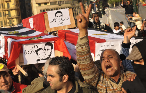 Egyptian protestors chant slogans against the country's ruling military while holding coffins symbolizing recent clashes in Tahrir Square in Cairo, Egypt, Friday, Dec. 2, 2011. Islamists appear to have taken a strong majority of seats in the first round of Egypt's first parliamentary vote since Hosni Mubarak's ouster, a trend that if confirmed would give religious parties a popular mandate in the struggle to win control from the ruling military and ultimately reshape a key U.S. ally. (AP Photo/Bela Szandelszky)