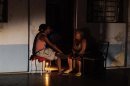 People sit at the door of their home during a power blackout in Havana