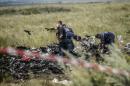 Ukrainian State Emergency Service employees search through debris at the site of the crash of a Malaysia Airlines plane in Grabove, in rebel-held east Ukraine on July 20, 2014