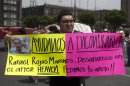 A man holds up a sign with details of his recently disappeared relative during a protest in Mexico City, Thursday, May 30, 2013. Eleven young people were kidnapped in broad daylight from a Mexico City bar, just 20 days after the grandson of civil rights leader Malcolm X was beaten to death at a nightclub in the capital, anguished relatives said Thursday. The sign reads in Spanish "Help us find him. Rafael Rojas Marines. Disappeared in the after-hours Heaven. Asking for your support!" The mother of one of the missing youths says 11 people in all vanished from the after-hours club about 1 ½ blocks from the U.S. embassy, on the other side of Reforma Avenue. (AP Photo/Eduardo Verdugo)