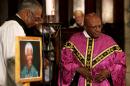Archbishop Emeritus Desmond Tutu, right, leads a prayer service in memory of former South African president Nelson Mandela, at St George's Cathedral in Cape Town, South Africa, Friday, Dec. 6, 2013. Mandela passed away Thursday night after a long illness. He was 95. As word of Mandela's death spread, current and former presidents, athletes and entertainers, and people around the world spoke about the life and legacy of the former South African leader. (AP Photo)