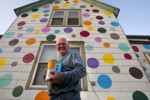 Jim Deitz puts the final touches on his polka dot house. (AP Photo/Grand Forks Herald, Eric Hylden)