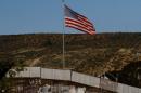 A U.S. flag is seen next to a section of the wall separating Mexico and the United States, in Tijuana