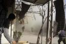 Smoke rises as people run at a site hit by shelling in Arbeen