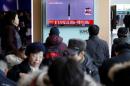Passengers watch a TV screen broadcasting a news report on North Korea firing a ballistic missile into the sea off its east coast, at a railway station in Seoul