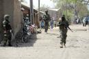 A photo taken on April 30, 2013 shows soldiers walking in the street in the remote northeast town of Baga, Borno State