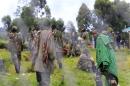 Congolese M23 rebels walk inside an enclosure after surrendering to Uganda's government at Rugwerero village in Kisoro district