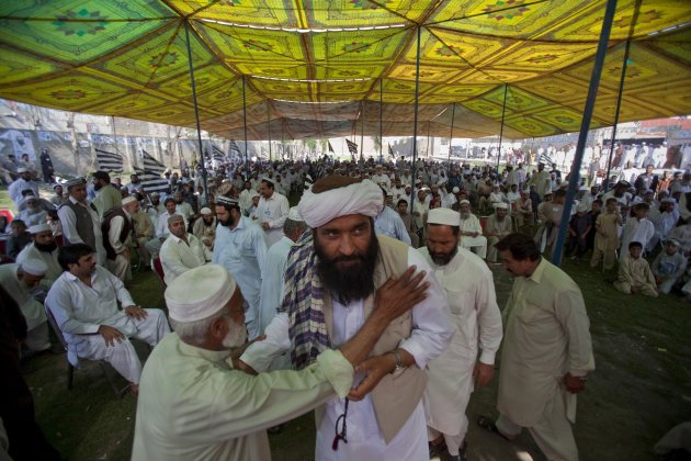 In this Thursday, May 2, 2013 photo, Maulana Shujaul Mulk, center, pro-Taliban Jamiat-e-Ulema Islam (JUI-F), is greeted by a supporter as he arrive to address an election campaign rally in Mardan, Pakistan. Mulk is among several Pakistani Islamists and sectarian groups contesting for the country's upcoming parliamentary elections, which are divided and scattered though, they are still in a position to secure enough strength to play Pakistani establishment bid to “hound” the next frail government in influencing its decisions about the U.S. forces withdrawal from Afghanistan in 2014. (AP Photo/Anjum Naveed)