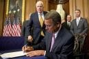 House Speaker John Boehner, R-Ohio, accompanied by Sen. John McCain, R-Ariz., left, and other congressmen, signs the National Defense Authorization Act. H-207, Tuesday, Oct. 20, 2015, in the Rayburn Room? at the Capitol in Washington. (AP Photo/Andrew Harnik)