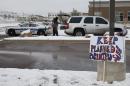 A sign in support of Planned Parenthood stands just south of the clinic as police investigators gather evidence near the scene of Friday's shooting at the clinic Sunday, Nov. 29, 2015, in northwest Colorado Springs, Colo. (AP Photo/David Zalubowski)