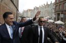 U.S. Republican Presidential candidate Romney waves to hundreds of people gathered outside before his meeting with Poland's PM Tusk at the Old Town Hall in Gdansk