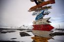In this Jan. 20, 2015 photo, wooden arrows show the distances to various cities near Chile's Escudero station on King George Island, Antarctica. Thousands of scientists come to Antarctica for research. There are also non-scientists, chefs, divers, mechanics, janitors and the priest of the world's southernmost Eastern Orthodox Church on top of a rocky hill at the Russian Bellinghausen station. (AP Photo/Natacha Pisarenko)