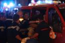 Rescue workers help injured people to get in a ambulance on July 15, 2016, after a truck drove into a crowd watching a fireworks display in the French Riviera town of Nice