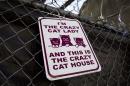 A sign is posted on fence at the location of where Members of the Pennsylvania Society for the Prevention of Cruelty to Animals remove cats from two connected row homes Wednesday, March 26, 2014, in Philadelphia. The Animal welfare authorities say they are working to remove about 260 cats and take them to the organization's north Philadelphia shelter, where veterinarians were waiting to examine them. (AP Photo/Matt Rourke)
