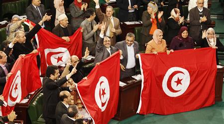 Members of the Tunisian parliament wave flags after approving the country's new constitution in the assembly building in Tunis January 26, 2014. REUTERS/Zoubeir Souissi