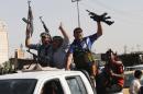 In this Saturday, June 14, 2014 Iraqi Shiite fighters deploy with their weapons in Basra, Iraq's second-largest city, 340 miles (550 kilometers) southeast of Baghdad, Iraq. Emboldened by a call to arms by the top Shiite cleric, Iranian-backed militias have moved quickly to the center of Iraq's political landscape, spearheading what its Shiite majority sees as a fight for survival against Sunni militants who control of large swaths of territory north of Baghdad. (AP Photo/ Nabil Al-Jurani)
