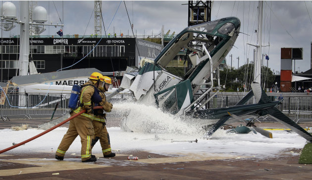 Firemen work at the scene of a helicopter accident in Auckland's Viaduct Basin, New Zealand, Wednesday, Nov. 23, 2011. The helicopter helping install a Christmas tree on Auckland's waterfront crashes 