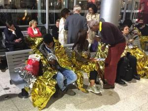 Passengers wrapped in thermal foil blankets given out by emergency services after their Eurostar train was stranded at Calais Station, after intruders were seen near the Eurotunnel, in Calais