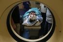 A wounded Palestinian man lies on a stretcher at a hospital in Gaza City following a strike on a training facility of the Ezzedine al-Qassam Brigades near El Bureij refugee camp on August 7, 2015