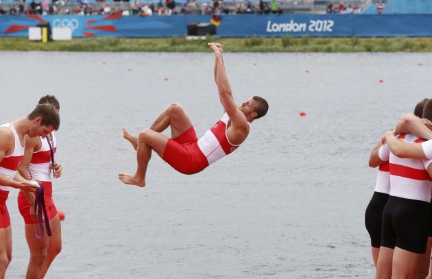 A Team Canada member jumps into the water to celebrate their second place in the men's eight Final A to win silver during the victory ceremony at Eton Dorney during the London 2012 Olympic Games