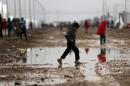 A displaced Iraqi child, who fled the fighting between IS group jihadists and government forces around Mosul, walks through the mud at the al-Khazir camp for displaced people, between Arbil and Mosul, on December 1, 2016
