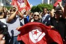 Anti-government protesters wave Tunisian flags as they rally for the dissolution of the Islamist-led government in Sfax