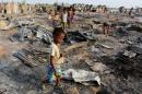 A boy walks among debris after fire destroyed shelters at a camp for internally displaced Rohingya Muslims in the western Rakhine State near Sittwe