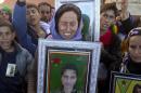 Jamila, center, sister of 19 year-old Syrian Kurdish fighter girl Perwin Mustafa Dihap who died after being wounded during fighting against the Islamic State forces in her home town of Kobani, cries holding her picture, during the funeral in Suruc, on the Turkey-Syria border Friday, Nov. 7, 2014. Kobani, also known as Ayn Arab, and its surrounding areas, has been under assault by extremists of the Islamic State group since mid-September and is being defended by Kurdish fighters. (AP Photo/Vadim Ghirda)