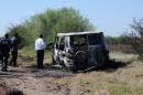 Forensic personnel stand by a burned van which two Australian citizens were allegedly travelling in, through the Sinaloa state, near Novolato, Mexico on November 21, 2015