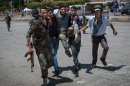 Syrian rebels rush a wounded man to Bab al-Hawa hospital near the rebel-controlled border with Turkey on July 1, 2013