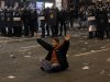 A protestor sits in front of the riot police riot to stop the clashes during a general strike in Madrid, Spain, Wednesday, Nov. 14, 2012. Spain's main trade unions stage a general strike, coinciding with similar work stoppages in Portugal and Greece, to protest government-imposed austerity measures and labor reforms. The strike is the second in Spain this year. (AP Photo/Andres Kudacki)
